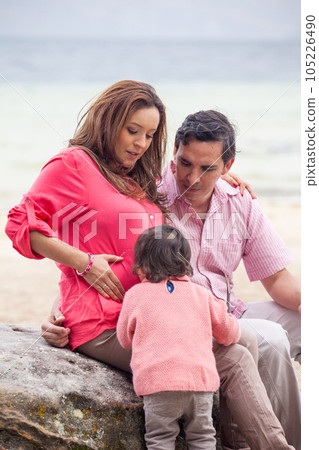 Young couple waiting for their second baby having fun with their baby girl at the beautiful white beach of Lake Tota located in the department of Boyaca at 3,015 meters above sea level in Colombia Young couple waiting for their second baby having fun with their baby girl at the beautiful white beach of Lake Tota located in the department of Boyaca at 3,015 meters above sea level in Colombia 105226490
