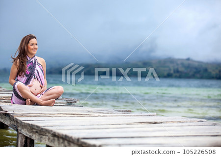 Portrait of a young woman waiting for her baby at the beautiful white beach of Lake Tota located in the department of Boyaca at 3,015 meters above sea level in Colombia 105226508