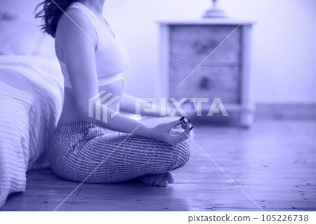 Smiling young brown haired woman in pajamas practicing yoga Smiling young brown haired woman in pajamas practicing yoga 105226738