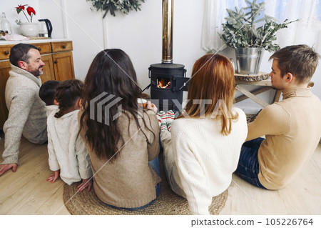 Cropped photo of big family wearing warm woolen socks resting by fireplace together in winter time 105226764