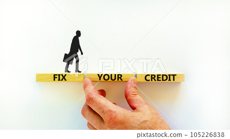Fix your credit symbol. Concept words Fix your credit on wooden blocks on a beautiful white table white background. Businessman hand. Business, finacial and fix your credit concept. Copy space. 105226838