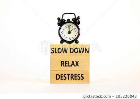 Destress symbol. Concept words Slow down Relax Destress on wooden block. Black alarm clock. Beautiful white table white background. Psychological business slow down Relax destress concept. Copy space. 105226848