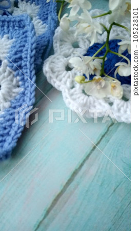 Blue, white crochet elements and orchid. Crochet texture, place for an inscription, adapted for mobile phone Blue, white crochet elements and orchid. Crochet texture, place for an inscription, adapted for mobile phone 105228101