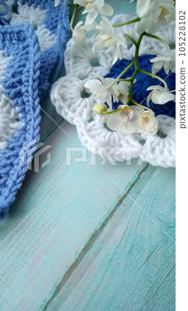 Blue, white crochet elements and orchid. Crochet texture, place for an inscription, adapted for mobile phone Blue, white crochet elements and orchid. Crochet texture, place for an inscription, adapted for mobile phone 105228102