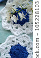 Blue, white crochet elements and orchid. Crochet texture, place for an inscription, adapted for mobile phone 105228103