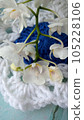 Blue, white crochet elements and orchid. Crochet texture, place for an inscription, adapted for mobile phone 105228106