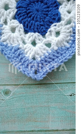 Blue, white crochet elements and orchid. Crochet texture, place for an inscription, adapted for mobile phone Blue, white crochet elements and orchid. Crochet texture, place for an inscription, adapted for mobile phone 105228109