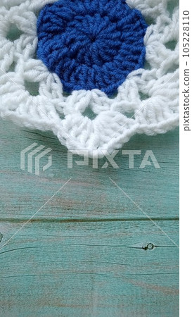 Blue, white crochet elements and orchid. Crochet texture, place for an inscription, adapted for mobile phone Blue, white crochet elements and orchid. Crochet texture, place for an inscription, adapted for mobile phone 105228110