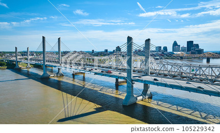 Two suspension bridges over Ohio River downtown Louisville Kentucky partially cloudy aerial 105229342