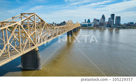 White gold bridge over murky brown river water aerial Ohio River Louisville skyscraper downtown 105229357