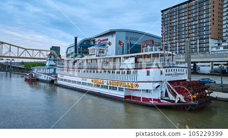 Aerial over Ohio River water red steamboat paddlewheel next to city Belle Louisville 105229399