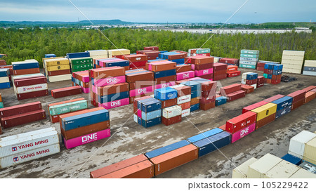 Aerial shipping container port, colorful semi truck containers stacked in shipping yard Aerial shipping container port, colorful semi truck containers stacked in shipping yard 105229422