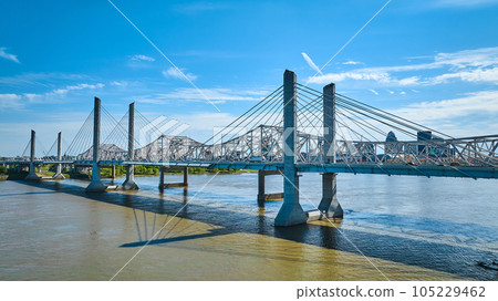 Two suspension bridges over Ohio River in Louisville Kentucky partially cloudy aerial 105229462