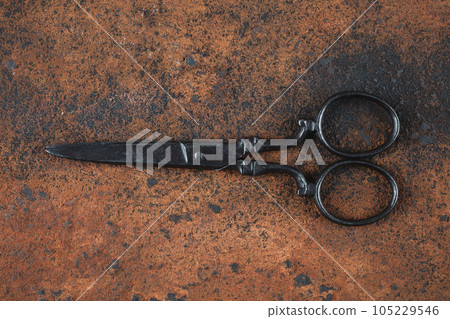 Vintage embroidery scissors on rusty background Vintage embroidery scissors on rusty background 105229546