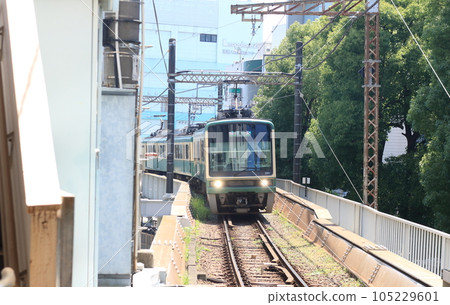 Enoden, a local train running between houses Enoden, a local train running between houses 105229601