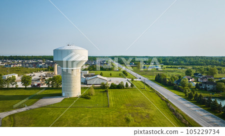 Nondescript white water tower with nearby housing rural area aerial Nondescript white water tower with nearby housing rural area aerial 105229734