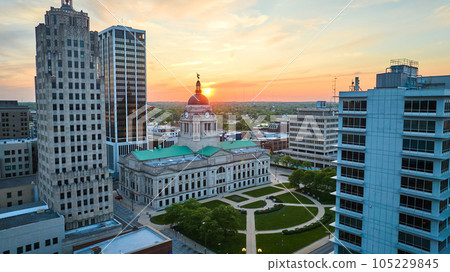 Golden sun peaking over horizon behind courthouse in aerial of downtown Fort Wayne Golden sun peaking over horizon behind courthouse in aerial of downtown Fort Wayne 105229845