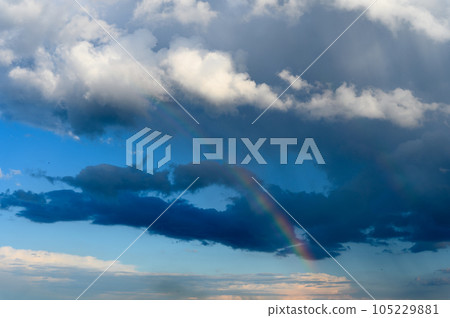 Amazing bright rainbow in a beautiful blue cloudy sky after rain and thunder Amazing bright rainbow in a beautiful blue cloudy sky after rain and thunder 105229881