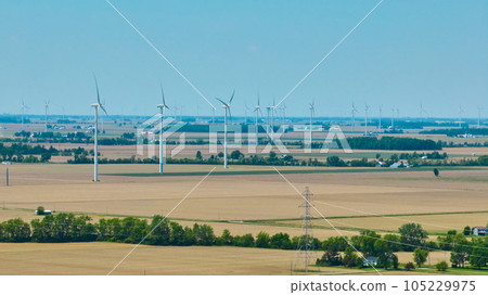 Wind farm aerial with power lines on summer day Wind farm aerial with power lines on summer day 105229975