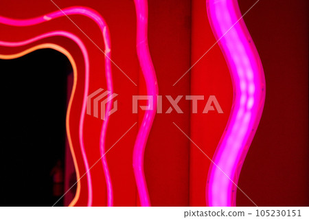 Pink neon lights leading up to a dark doorway 105230151