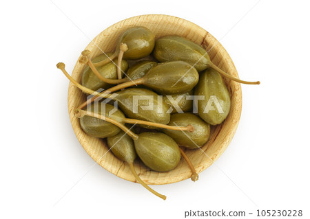 Capers in wooden bowl isolated on white background. Pickled or canned capers. Top view. Flat lay Capers in wooden bowl isolated on white background. Pickled or canned capers. Top view. Flat lay 105230228