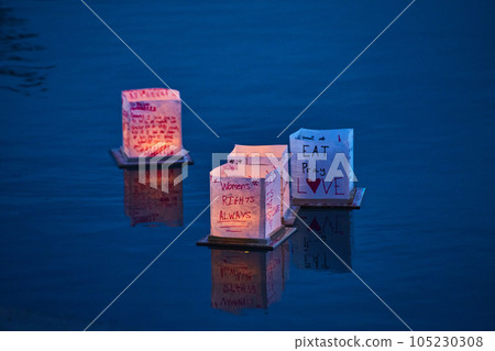 Four Japanese style lanters floating on peaceful pond Four Japanese style lanters floating on peaceful pond 105230308
