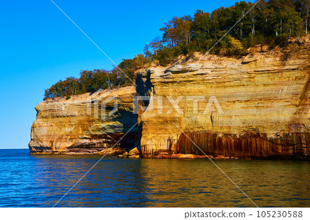 Cliff wall of pictured rocks at Michigan National Park with forest atop large cliffs 105230588