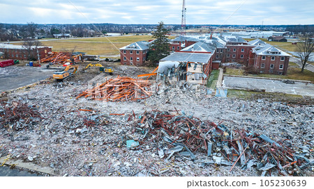 Drone aerial of deconstruction site of old abandoned hospital building with decay at Byron Health Center with multiple scrap piles Drone aerial of deconstruction site of old abandoned hospital building with decay at Byron Health Center with multiple scrap piles 105230639