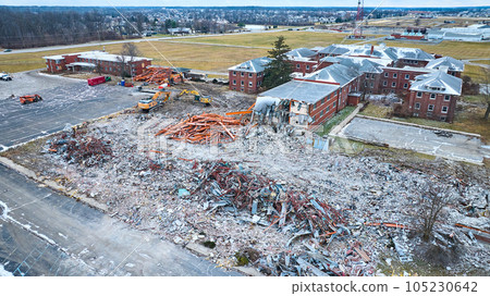 Drone aerial of deconstruction site of old abandoned hospital building with decay at Byron Health Center with half the buildings torn down 105230642