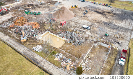 Remnant of a pool at construction zone with piles of scrap and debris 105230690