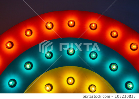 Red, blue, and yellow rings of light on rainbow wave art piece Red, blue, and yellow rings of light on rainbow wave art piece 105230833