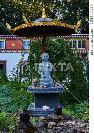 Golden umbrella and stone statue at old shrine 105231139