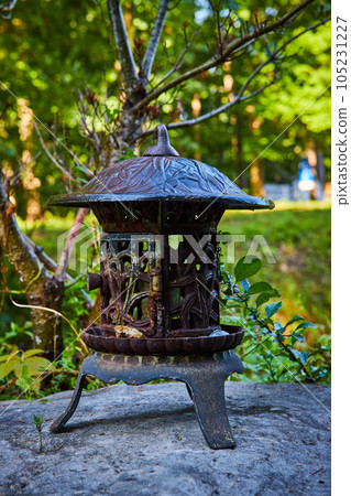 Small metal Tibetan Mongolian Buddhist lantern on rocks in forest 105231227