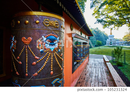 Shrine with several prayer wheels and Chorten structure in background Shrine with several prayer wheels and Chorten structure in background 105231324
