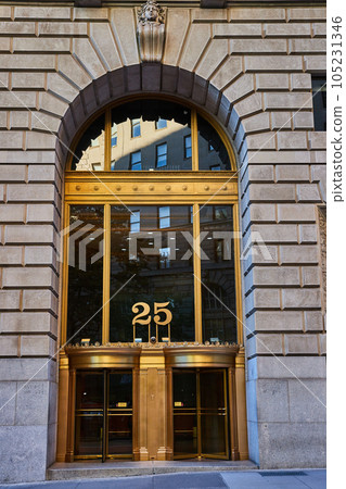 Outside New York City building 26 with golden frame and stone arch over huge entrance 105231346