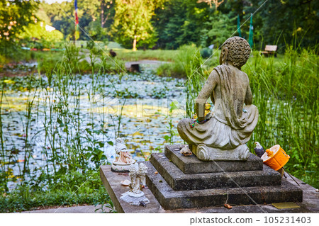 View from behind Tibetan Mongolian Buddhist statue overlooking lily pond 105231403