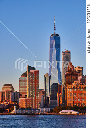 View of new One World Observatory in New York City from off coast of southern Manhattan in golden hour sunset light View of new One World Observatory in New York City from off coast of southern Manhattan in golden hour sunset light 105231556