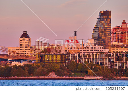 WELCOME sign on building of Brooklyn from coast with waters and buildings around during dusk light 105231607