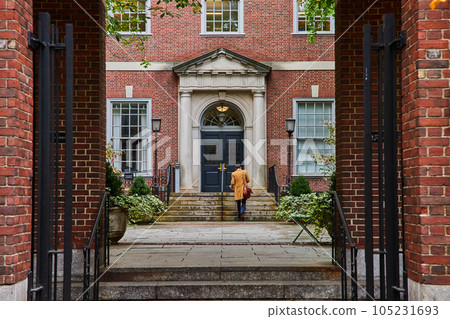 Law student walking through courtyard from brick arches in New York City straight on Law student walking through courtyard from brick arches in New York City straight on 105231693
