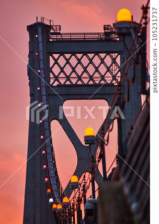 Orange lights in detail on support wires of American bridge with golden light behind Orange lights in detail on support wires of American bridge with golden light behind 105231737