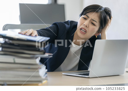 Desk work business woman holding her head 105233825
