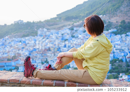 Woman overlooking the rooftops of Chefchaouen 105233912