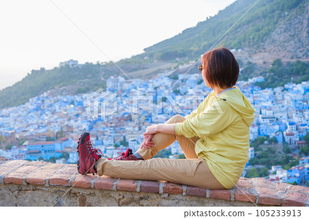 Woman overlooking the rooftops of Chefchaouen 105233913