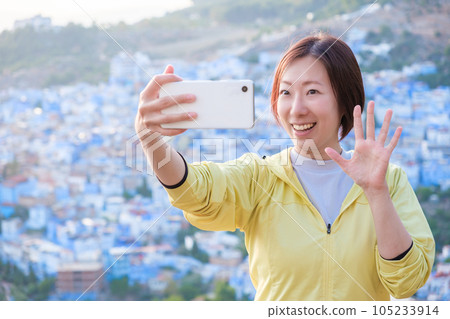 A woman taking a selfie in the streets of Chefchaouen A woman taking a selfie in the streets of Chefchaouen 105233914