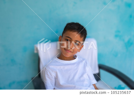 A cute boy with a smiling face healthy and cheerful..The cute boy wearing a white tee shirt spoke and made many expressions of emotions..Studio portrait, health concept with blue background. . A cute boy with a smiling face healthy and cheerful..The cute boy wearing a white tee shirt spoke and made many expressions of emotions..Studio portrait, health concept with blue background. . 105235637