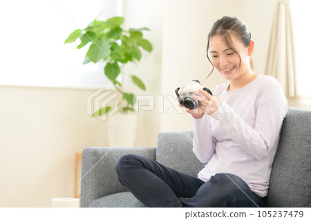 一位女士一邊看著相機屏幕一邊回憶 一位女士一邊看著相機屏幕一邊回憶 105237479