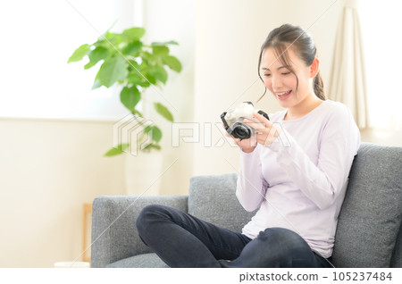 A woman reminiscing while looking at the camera screen 105237484