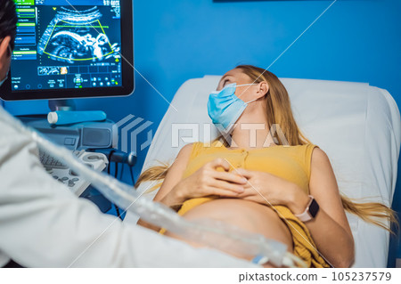 In the Hospital, Close-up Shot of the Doctor does Ultrasound Sonogram Procedure to a Pregnant Woman. Obstetrician Moving Transducer on the Belly of the Future Mother 105237579