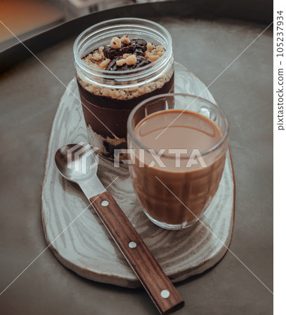 Good morning with Crumble dark chocolate brownie and Coffee in glass cup served with spoon on Ceramic tray. Good morning with Crumble dark chocolate brownie and Coffee in glass cup served with spoon on Ceramic tray. 105237934