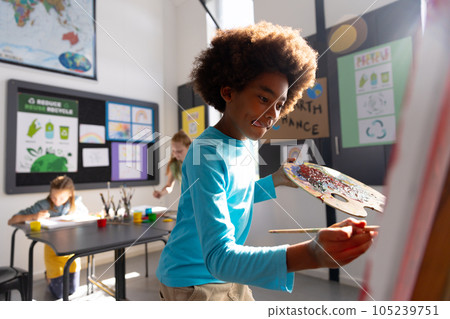 Happy diverse schoolchildren painting using brush and easel in school art class Happy diverse schoolchildren painting using brush and easel in school art class 105239751